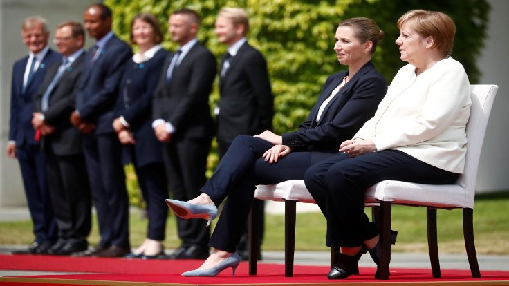 Merkel titrememek için törende oturdu