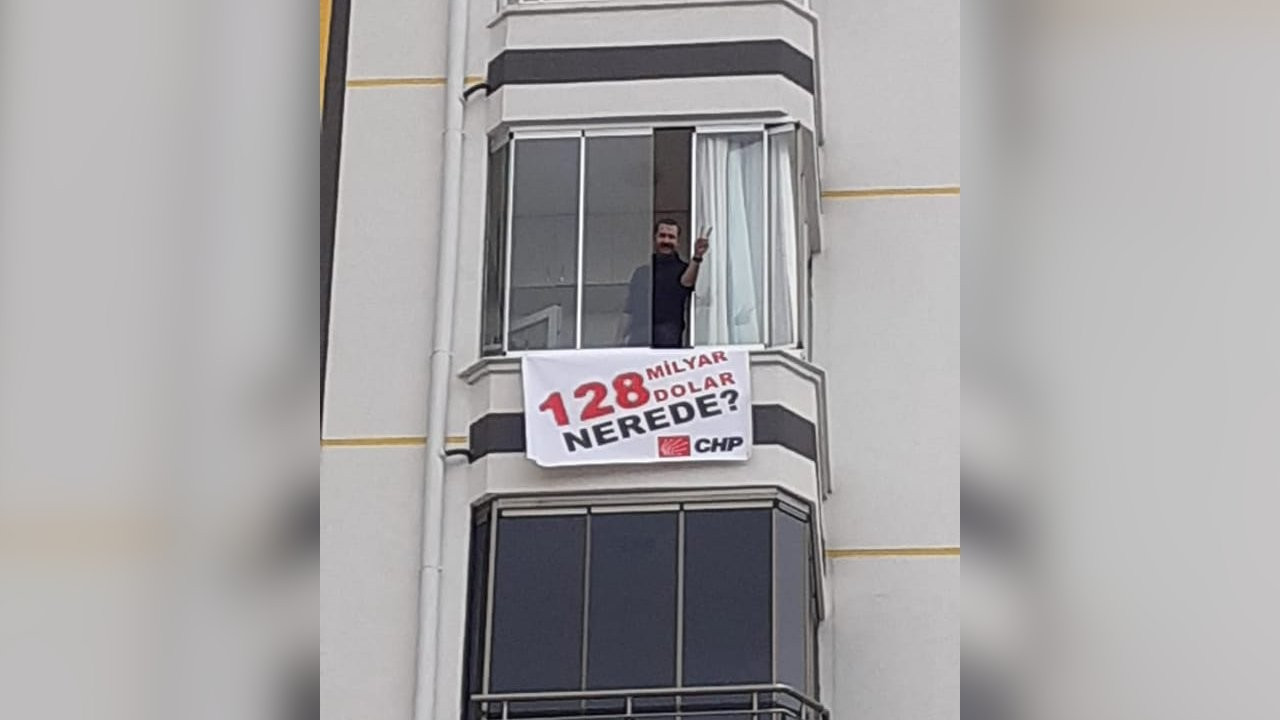 Balkonundaki '128 milyar dolar' afişi indirildi, suç duyurusunda bulundu